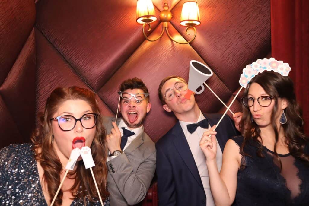 Invités avec des accessoires photobooth s'amusent lors d'un mariage