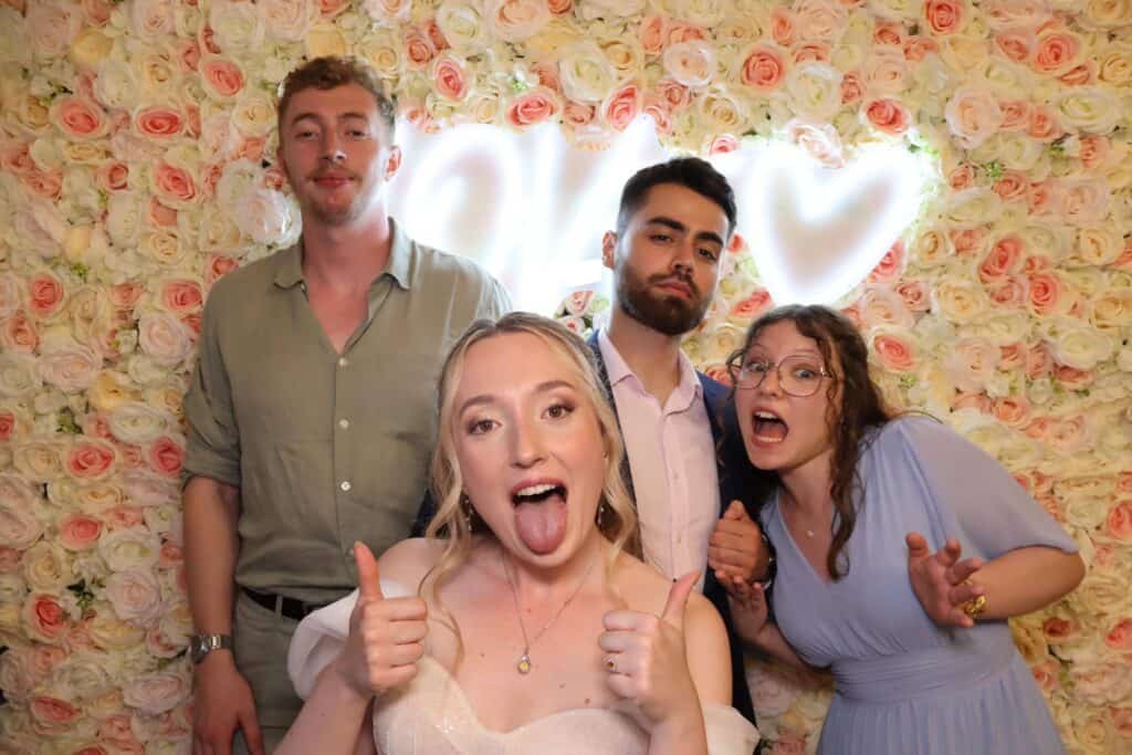 Invités qui lèvent le pouce devant le photobooth